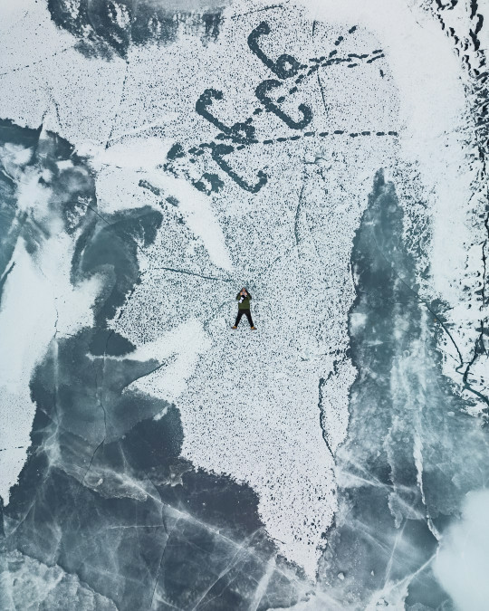 A man standing in the middle of a snow covered field