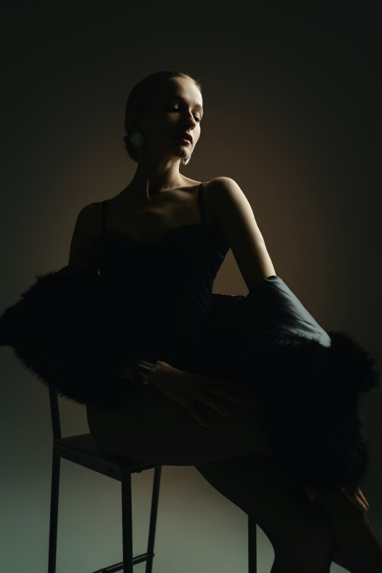 A woman sitting on a chair with her legs crossed