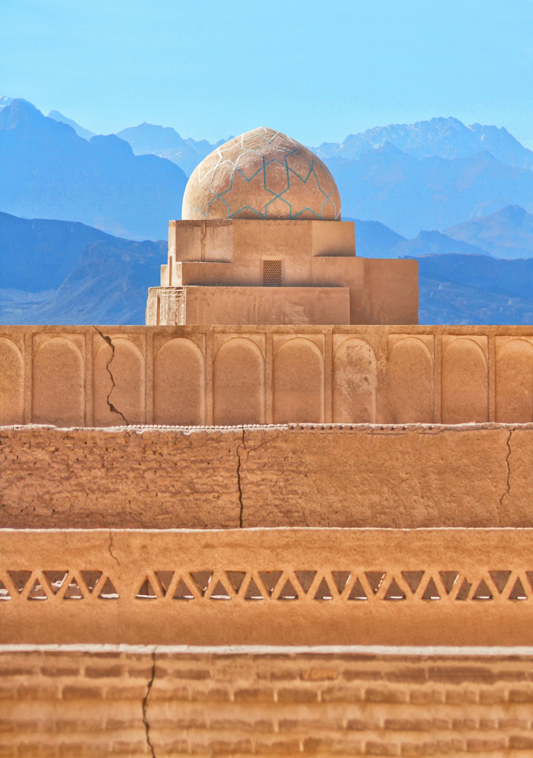 A building with a dome and mountains in the background