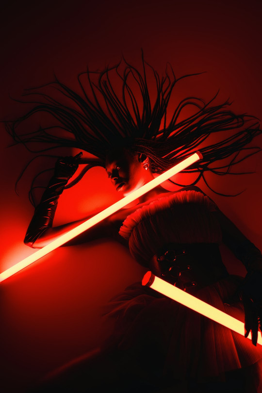 A woman with long hair holding a light saber