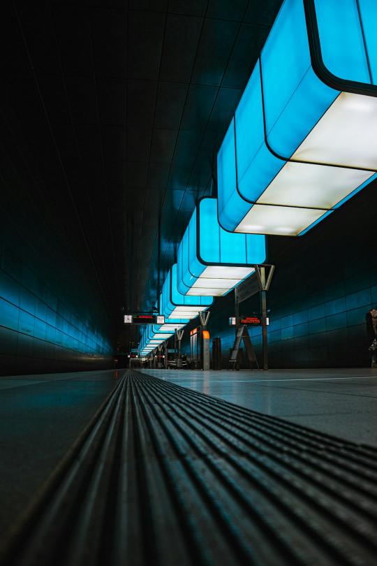 A long hallway with a blue light at the end of it