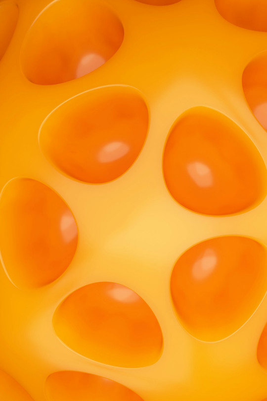 A close up of a yellow object with orange circles