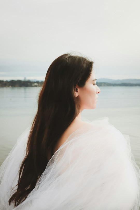 A woman in a white dress standing on a beach