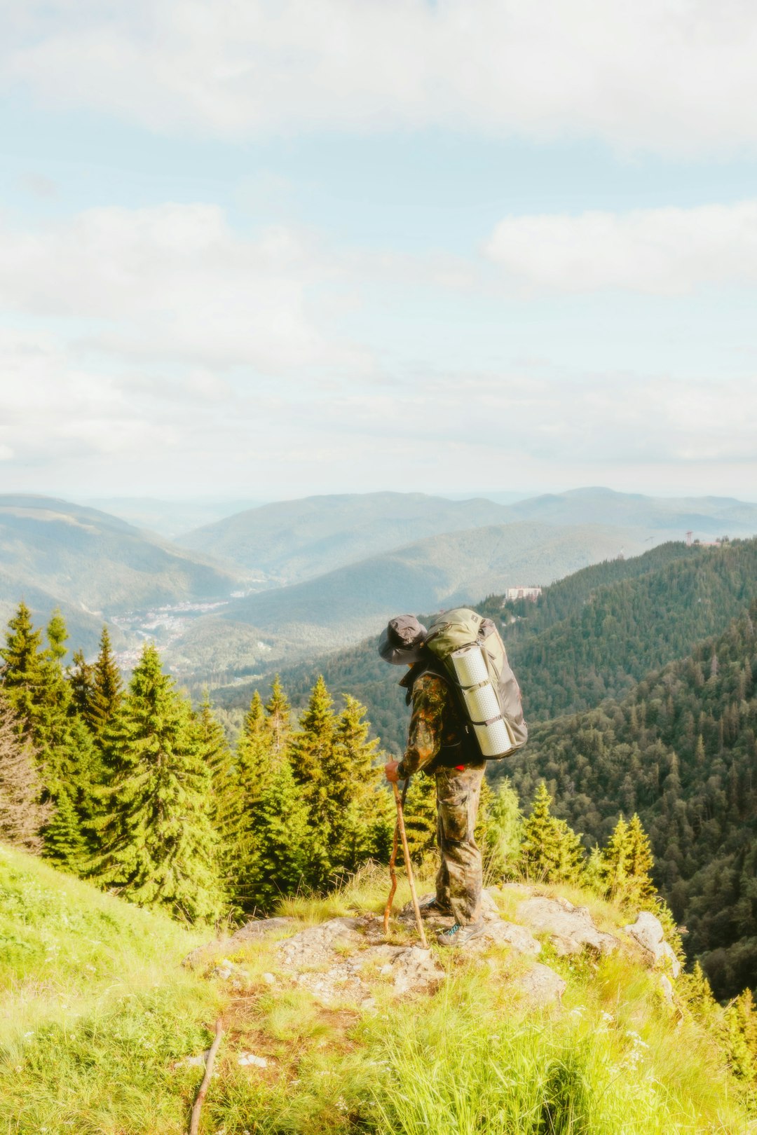 A man with a backpack is standing on a mountain