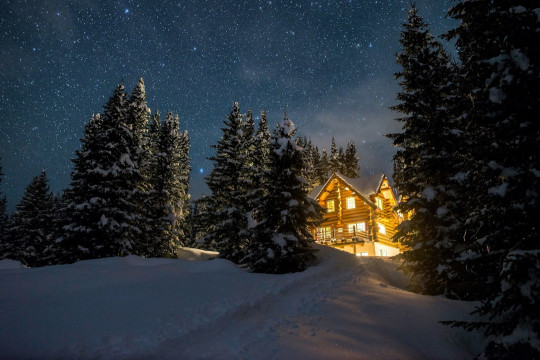 A house in the middle of a snow covered forest