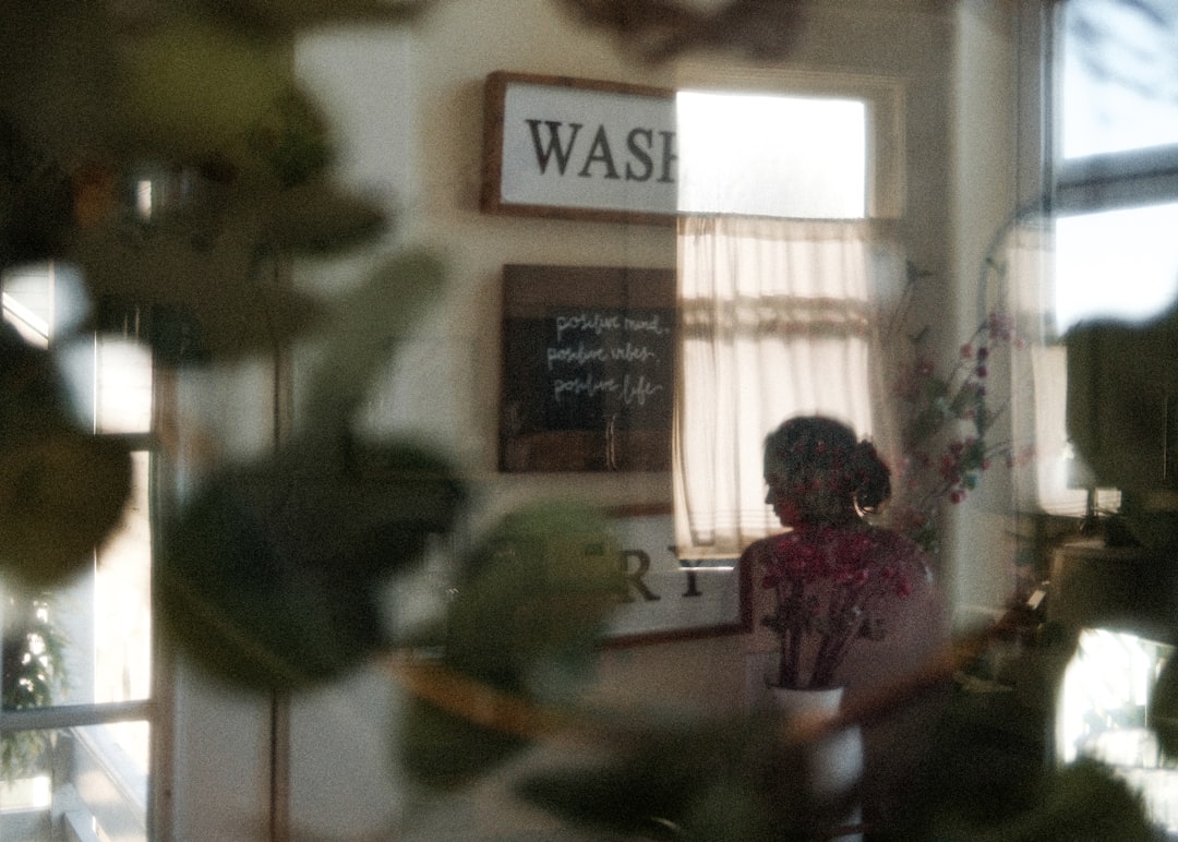 A woman standing in a kitchen next to a window