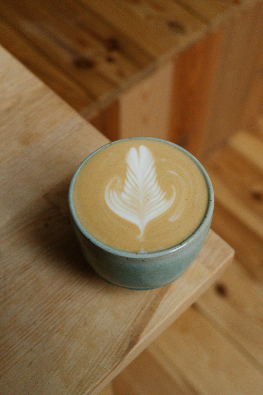 A cup of coffee with a leaf on it