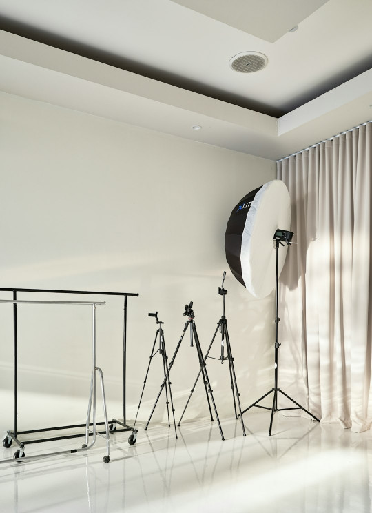 A photo studio with a white backdrop and light