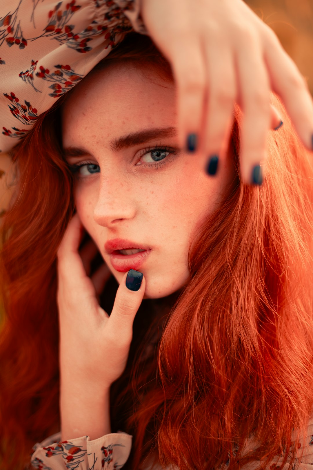 A woman with long red hair and blue eyes