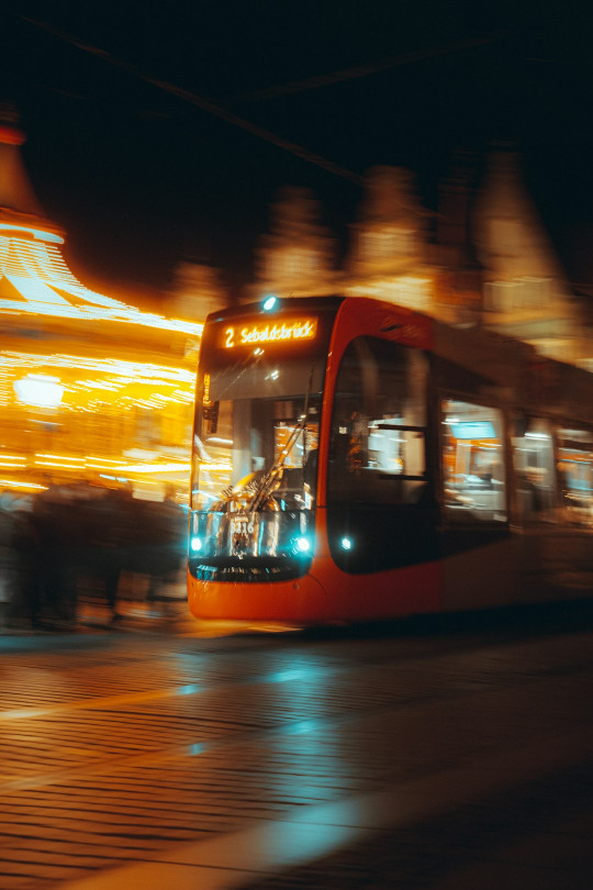 A city bus driving down a street at night