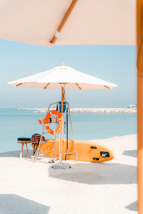 A lifeguard stand on the beach with a life preserver