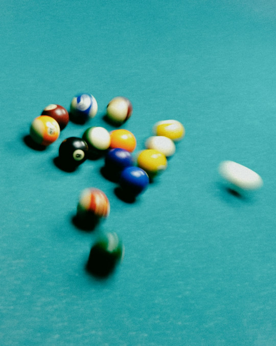 A pool table filled with pool balls on top of it