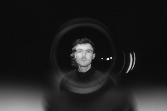 A man is seen through a circular lens