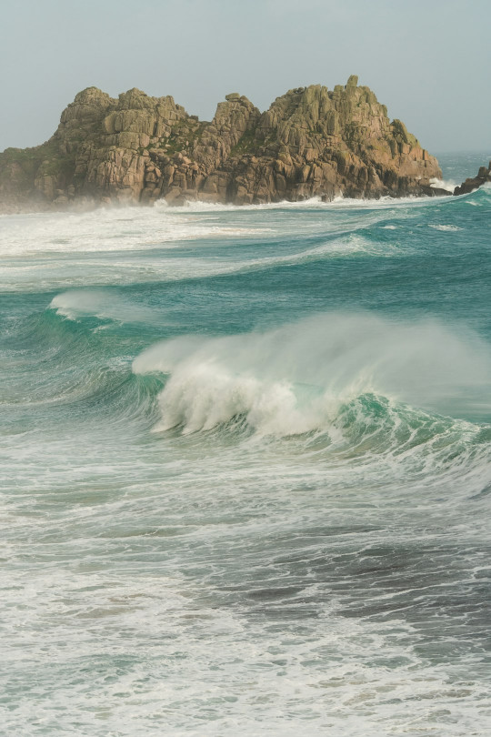 A man riding a surfboard on top of a wave in the ocean