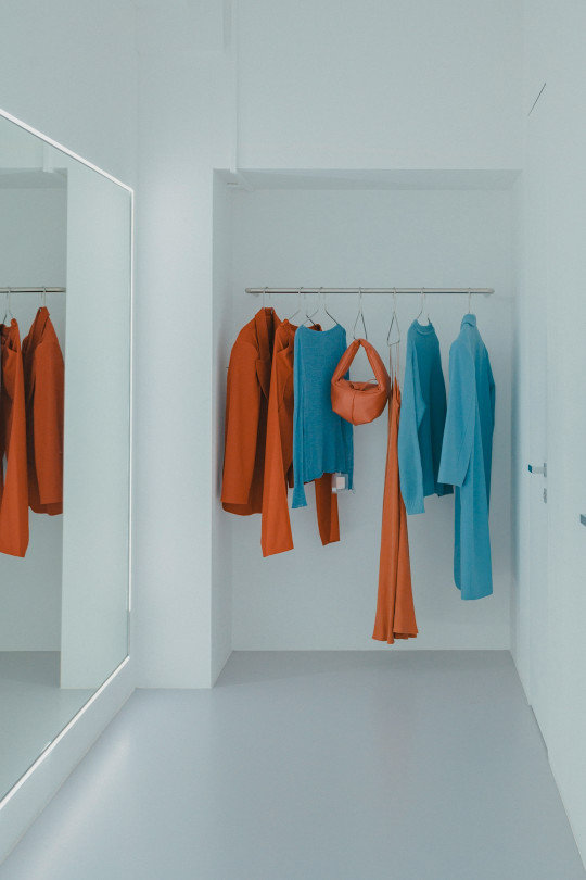 A white room with a mirror and a coat rack