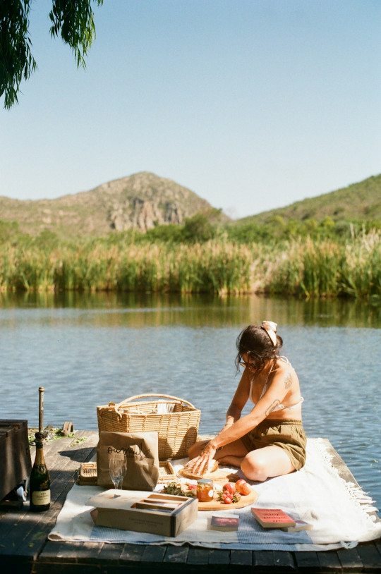 A woman is sitting on a dock by the water