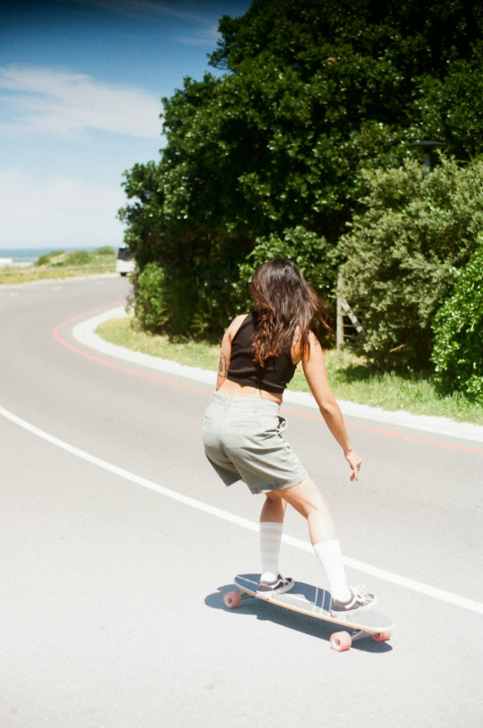 A woman riding a skateboard down a curvy road