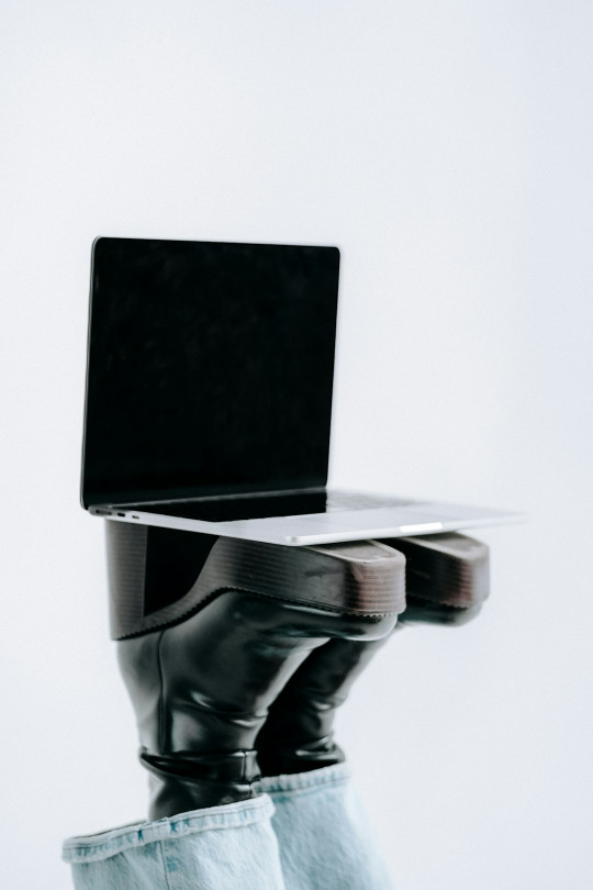 A laptop computer sitting on top of a pair of jeans