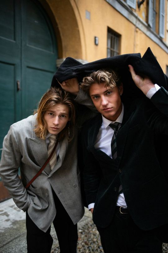 A man and a woman standing next to each other in front of a building