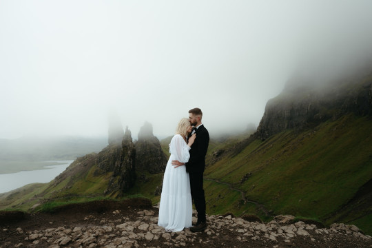 A man and a woman standing on top of a mountain