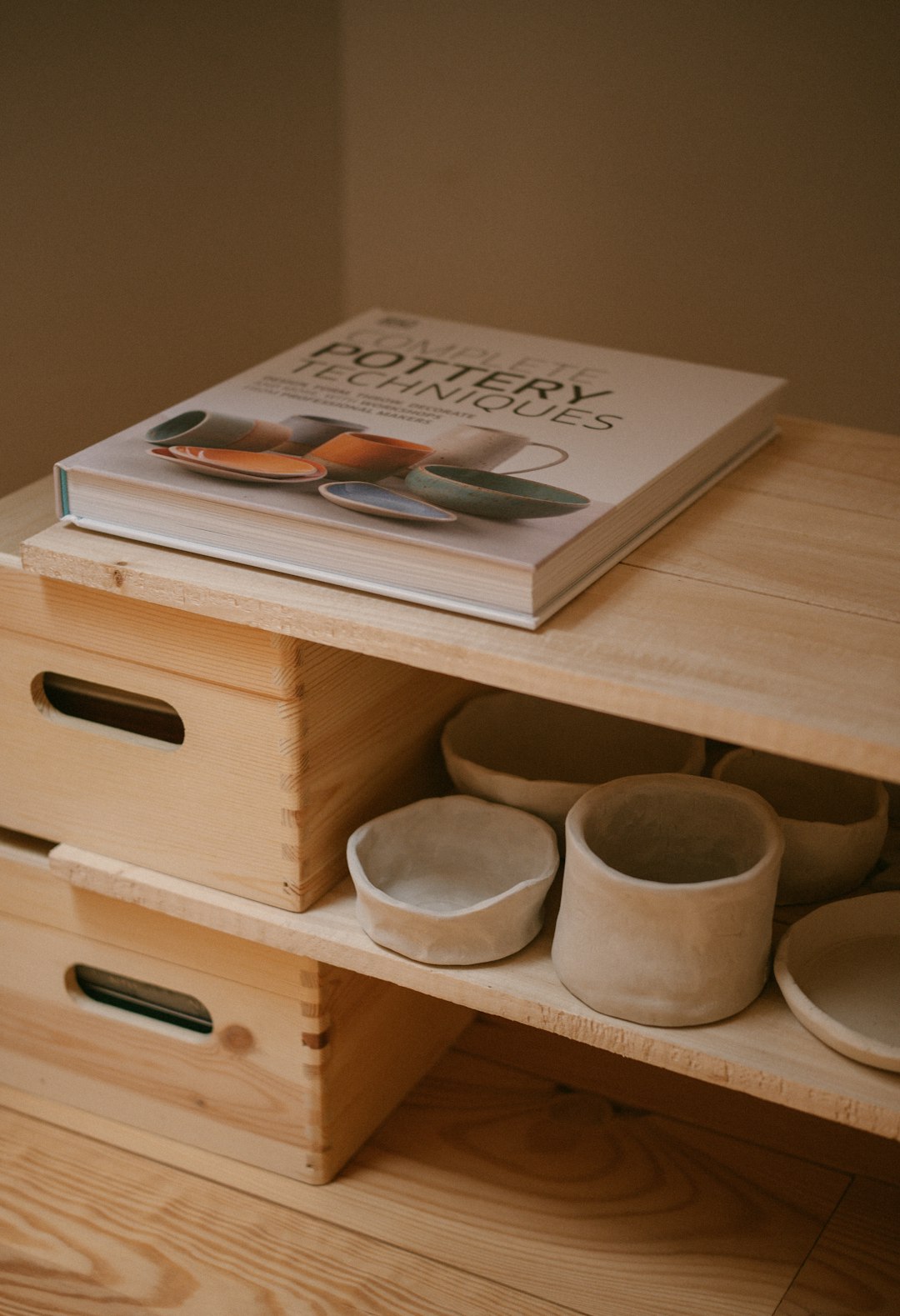 A book is sitting on top of a wooden shelf