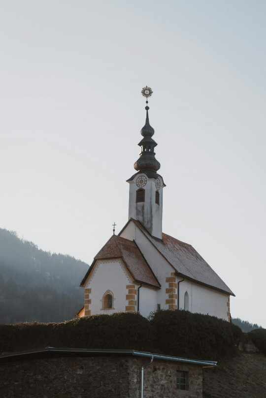 A church with a steeple on top of a hill