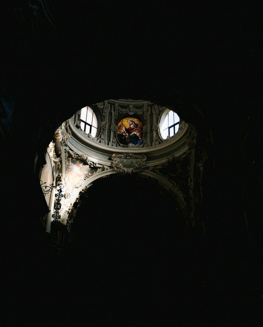 A view of a clock tower through a dark tunnel