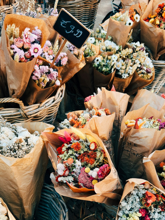 A bunch of baskets filled with lots of flowers