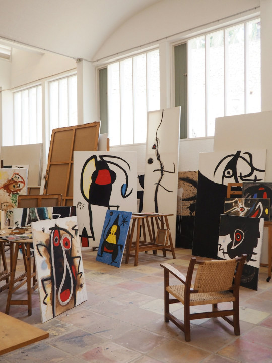 A room filled with lots of paintings and chairs