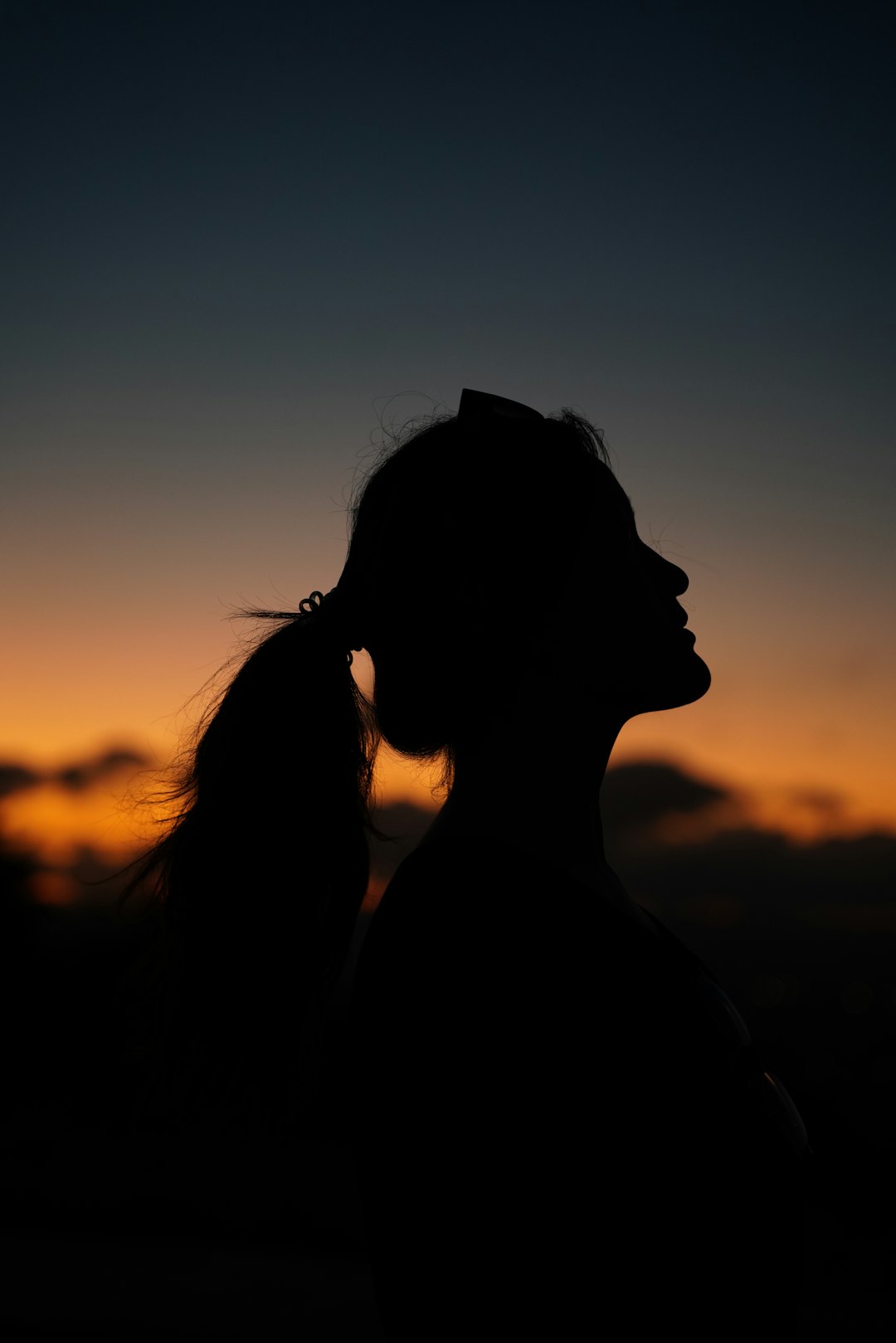 A silhouette of a woman at sunset