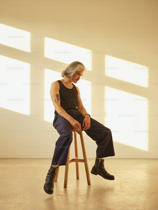 A man sitting on top of a wooden stool