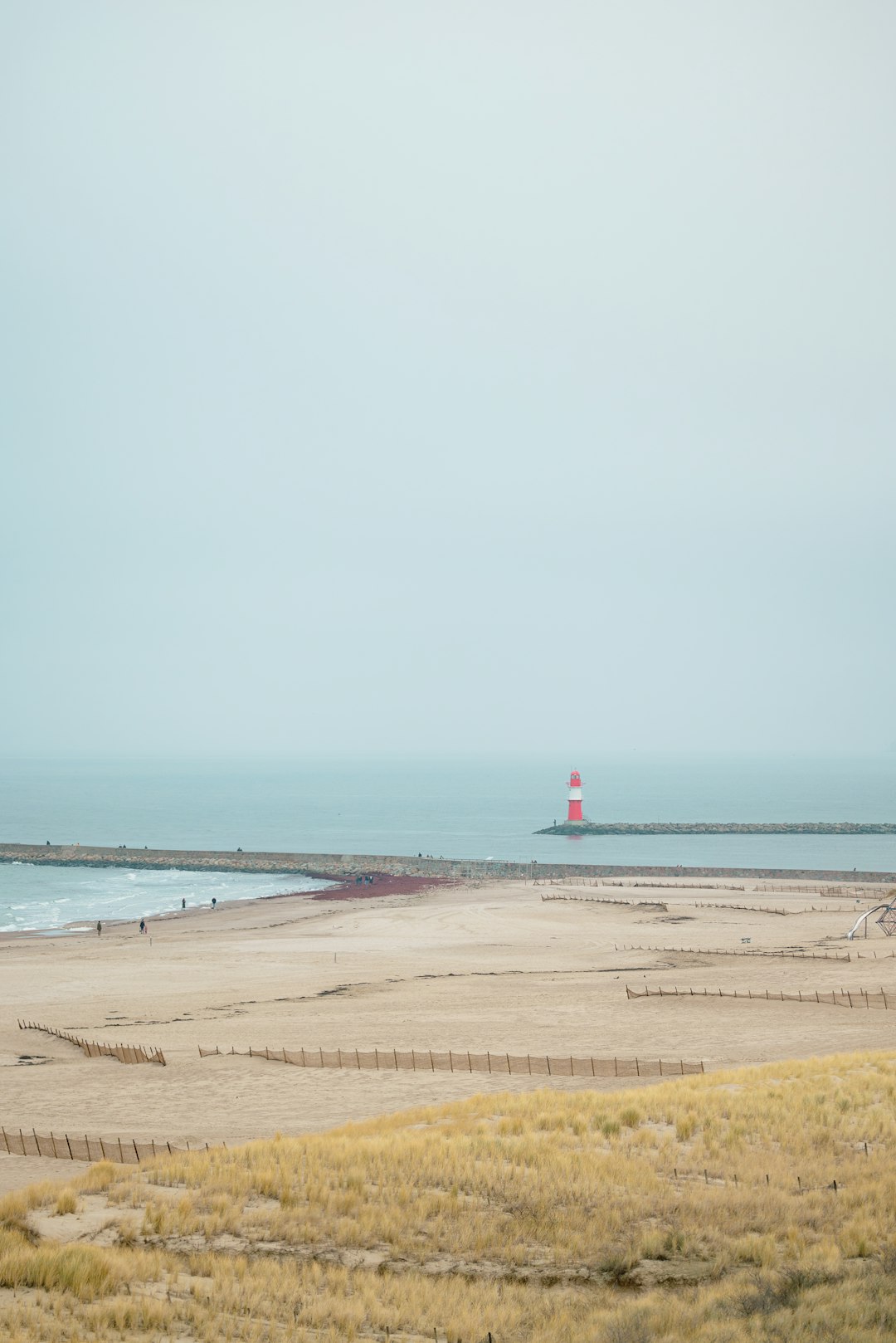 A beach with a light house in the distance