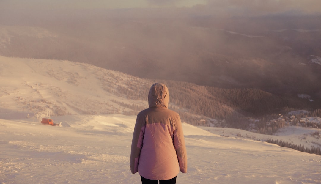 A woman standing on top of a snow covered slope