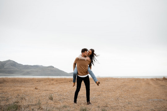 A man holding a woman in the middle of a field