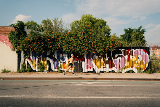 A wall covered in graffiti next to a street