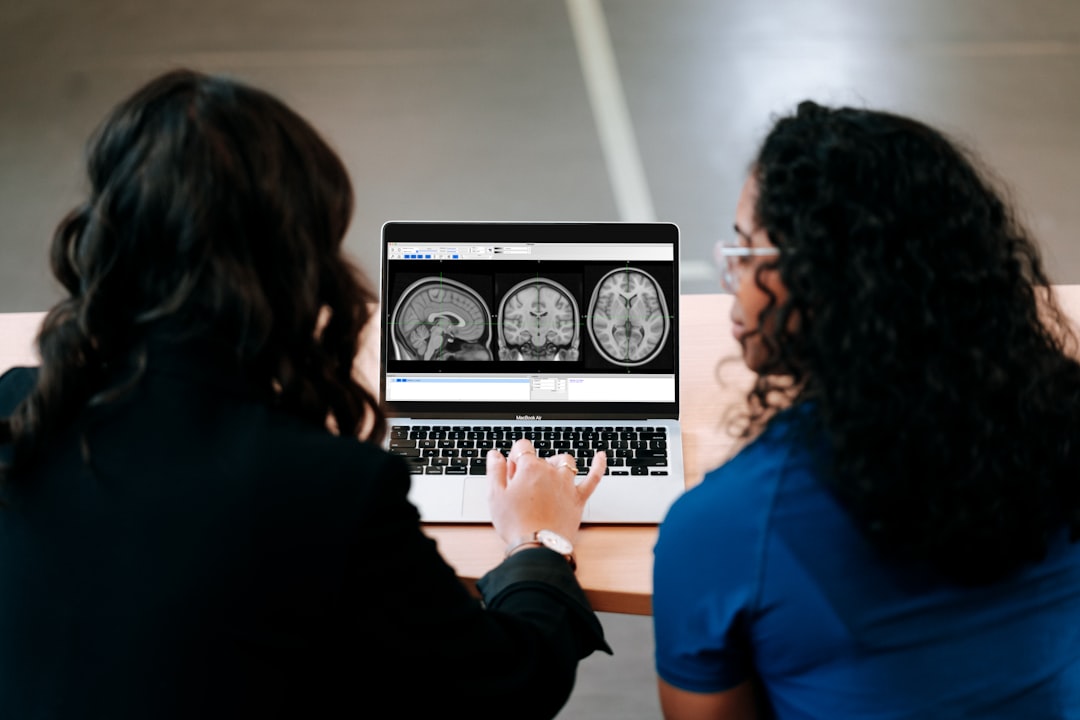 Two women looking at a computer screen with mri images on it