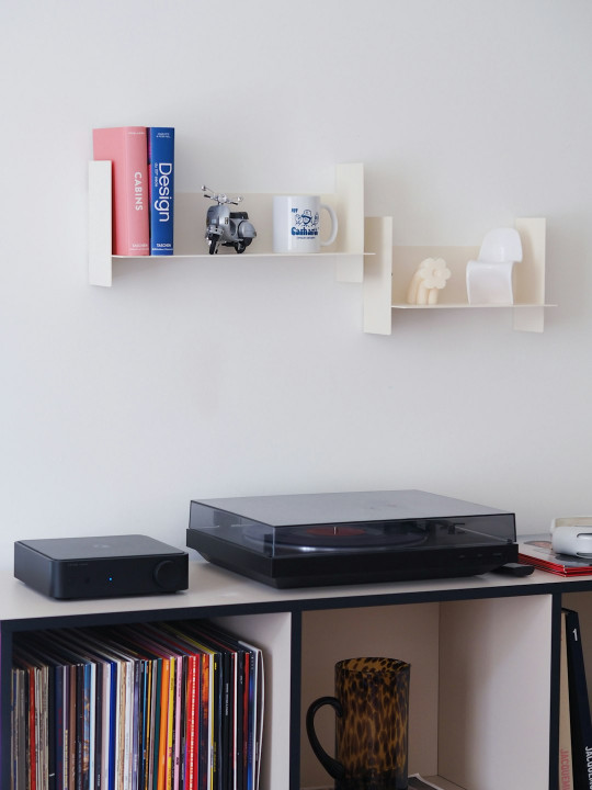 A shelf with a dvd player and a coffee mug