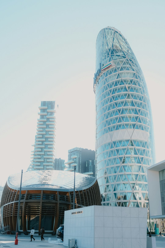 A tall building with a curved roof next to other buildings