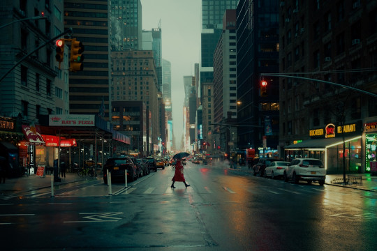 A woman walking down a street holding an umbrella