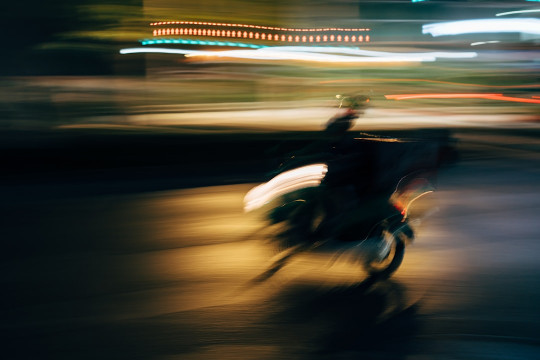 A blurry photo of a person riding a motorcycle