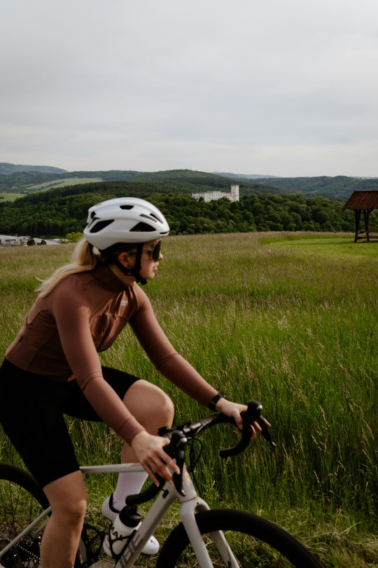 A woman riding a bike down a dirt road