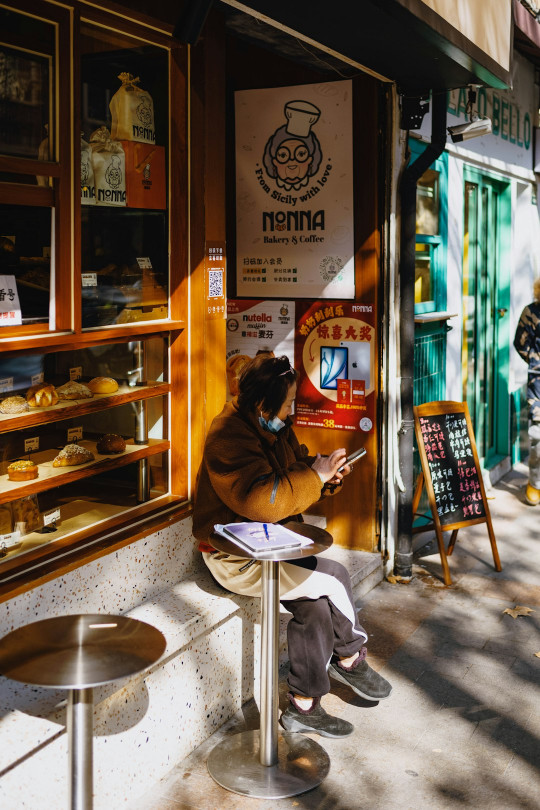 A person sitting on a bench in front of a store