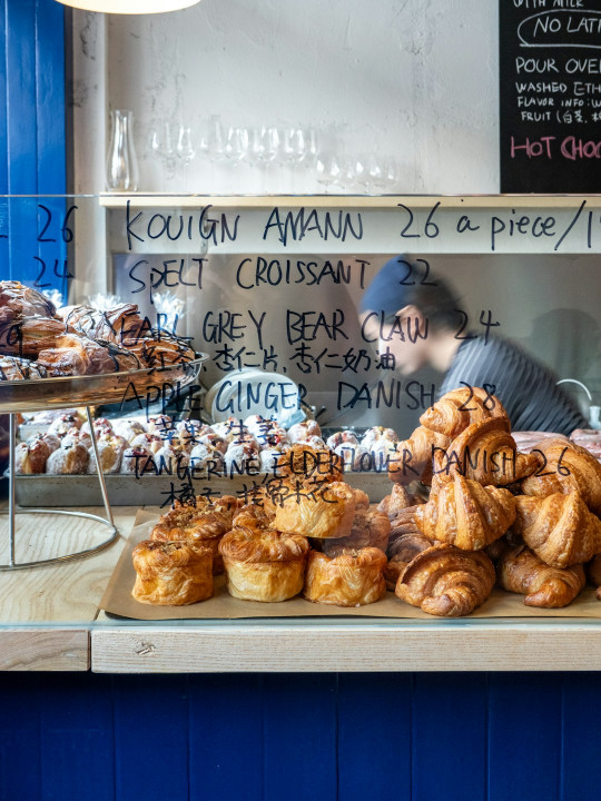 A man behind a counter filled with pastries