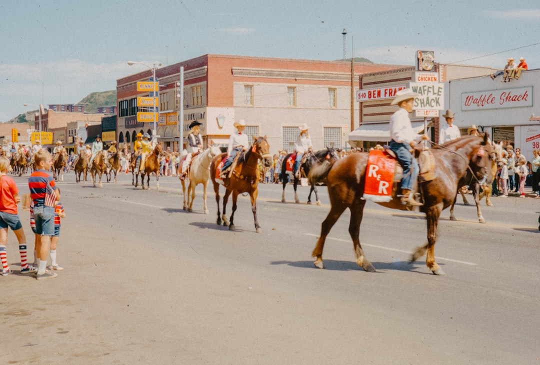 A group of people riding horses down a street