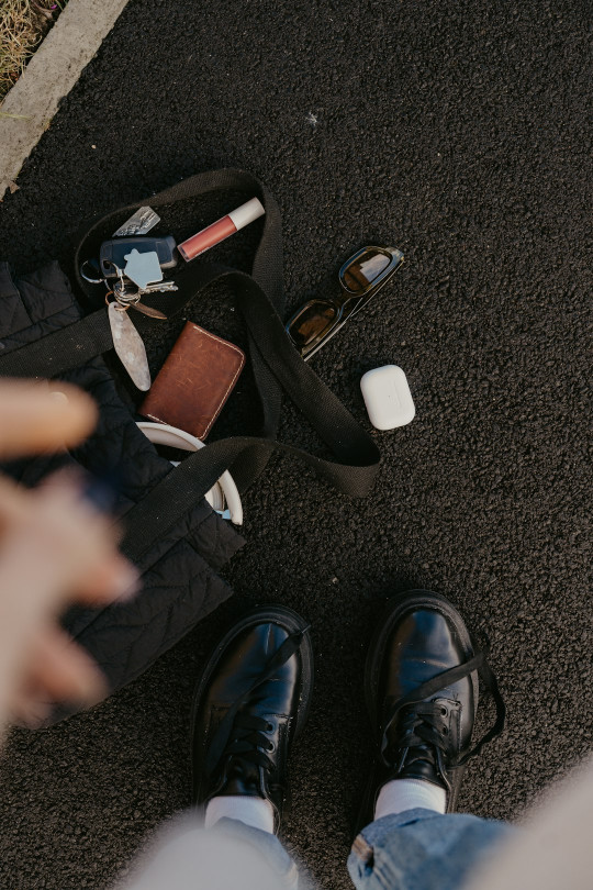 A person standing next to a pile of shoes