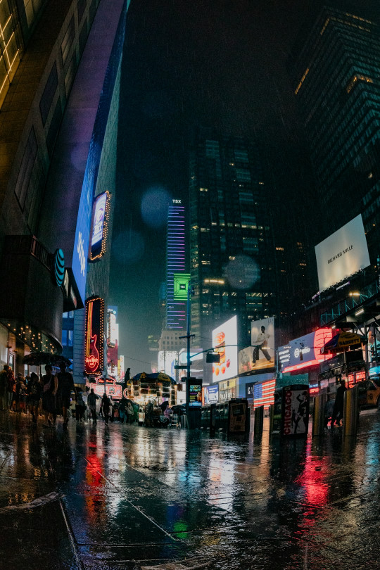 A city street at night with people crossing the street