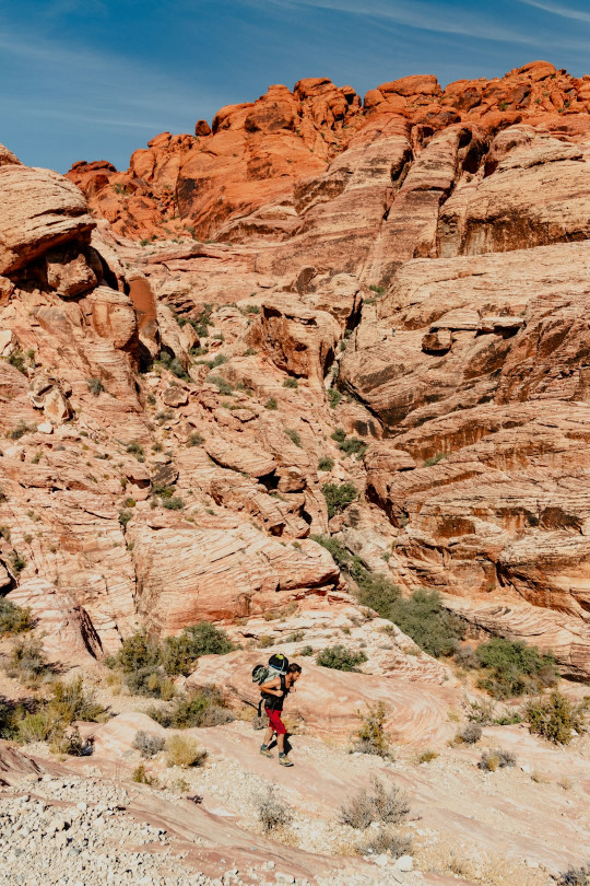 A man hiking up a mountain in the desert