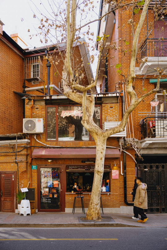 A person walking down the street in front of a building