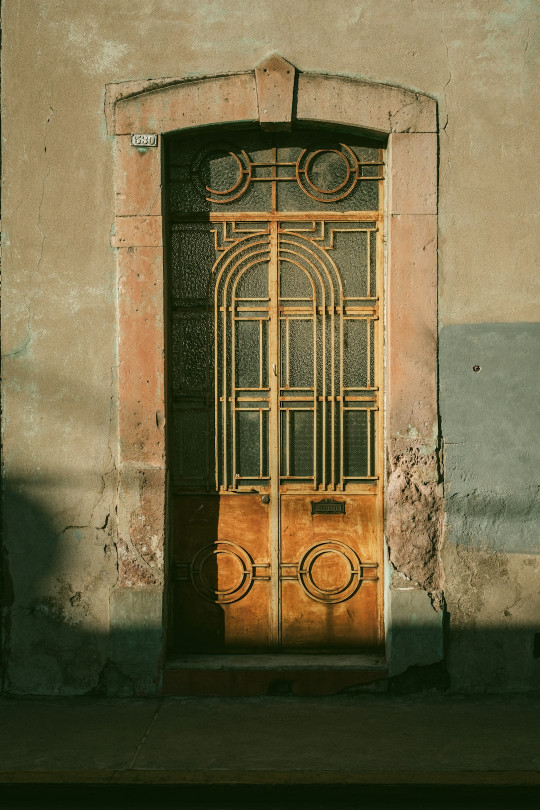 A yellow door is open on an old building