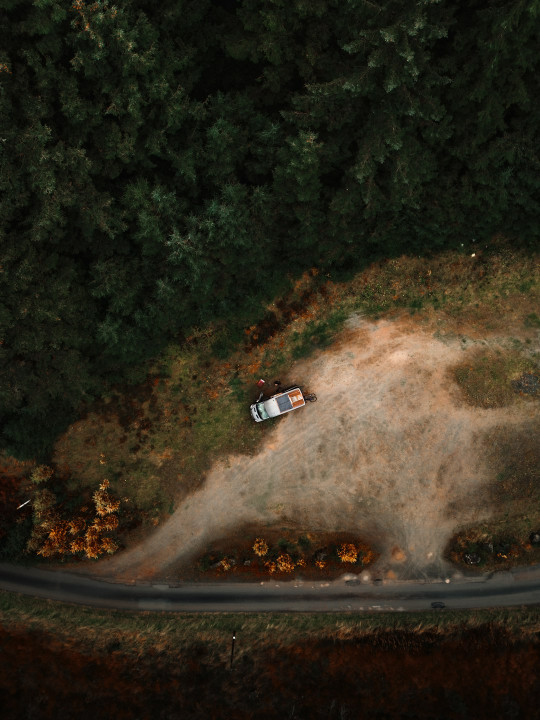 An aerial view of a car driving down a road